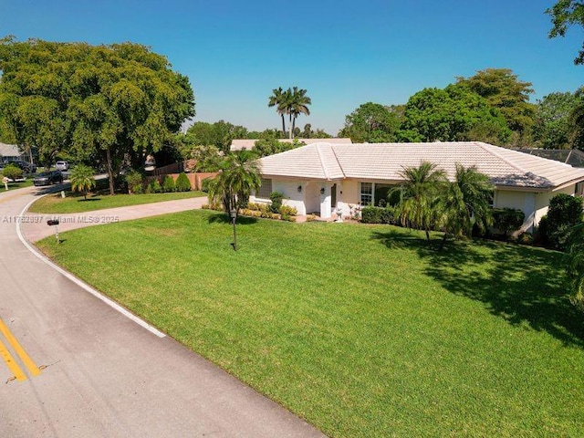 ranch-style house with a front yard and a tile roof