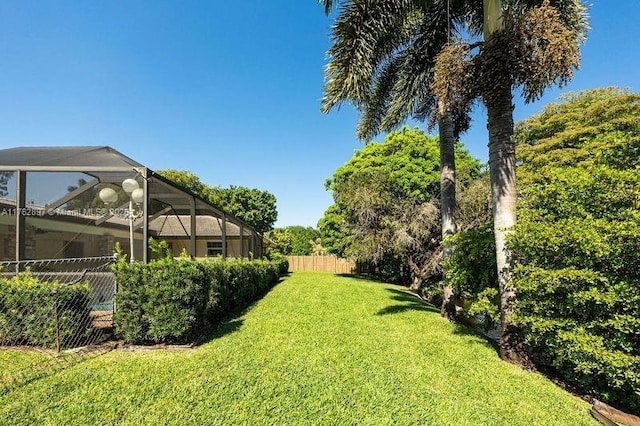 view of yard with a lanai and fence