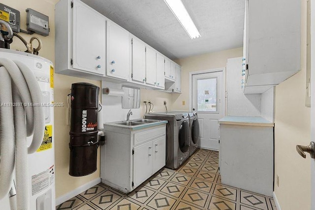 washroom with electric water heater, washer and clothes dryer, light floors, cabinet space, and a sink