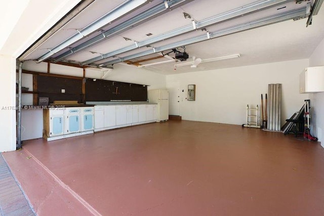 garage with electric panel, a garage door opener, and freestanding refrigerator