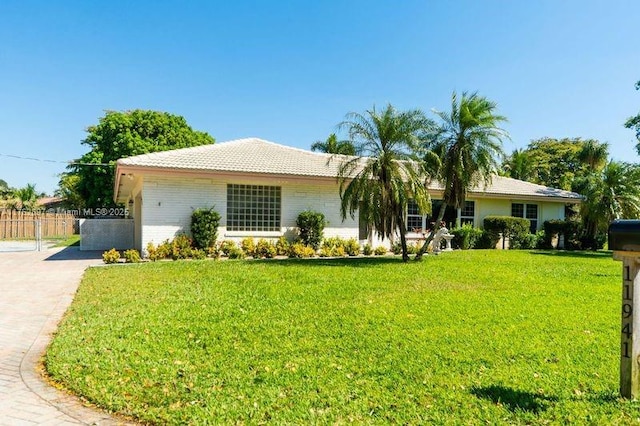 ranch-style house with a front lawn, fence, and driveway