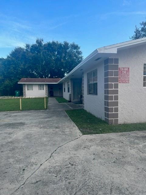 view of property exterior featuring a lawn and stucco siding