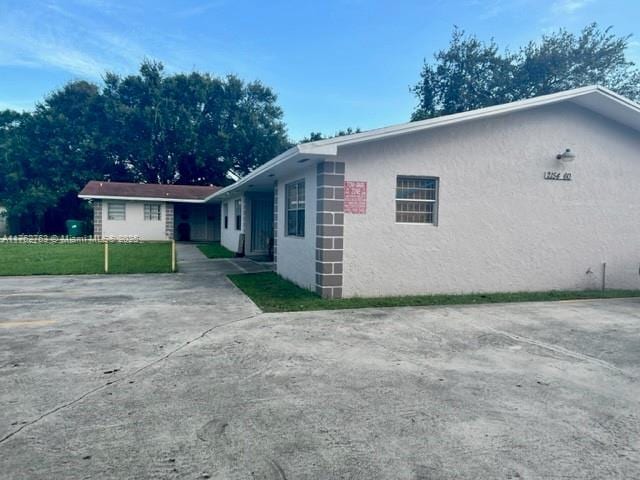 view of property exterior featuring stucco siding and a yard