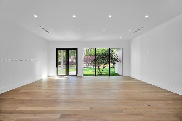 spare room with light wood finished floors, visible vents, recessed lighting, and baseboards