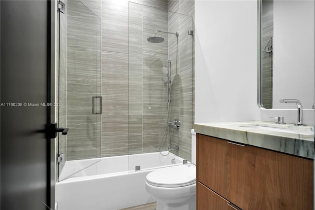 full bath with enclosed tub / shower combo, toilet, and vanity