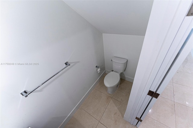 bathroom featuring tile patterned flooring, toilet, and baseboards