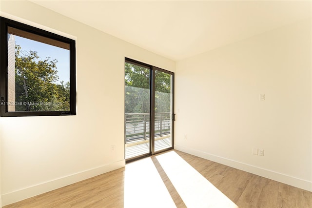 unfurnished room with light wood-style flooring and baseboards