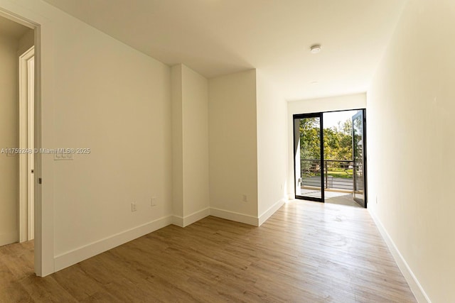 empty room with light wood-style flooring and baseboards