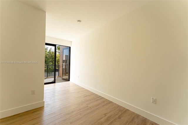 spare room featuring light wood finished floors and baseboards