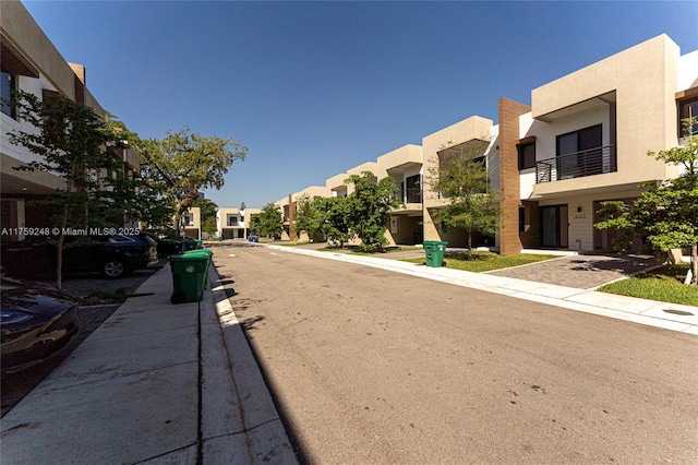 view of street with sidewalks, a residential view, and curbs