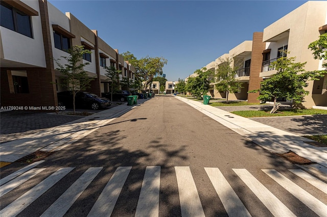 view of road with sidewalks, a residential view, and curbs