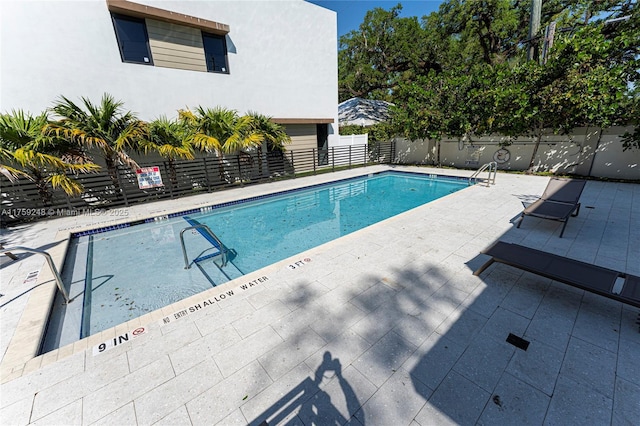 community pool featuring a patio area and fence