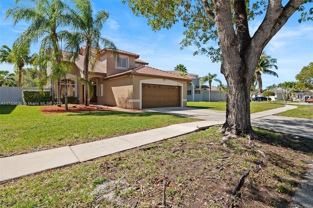 mediterranean / spanish house featuring a front lawn, fence, stucco siding, a garage, and driveway