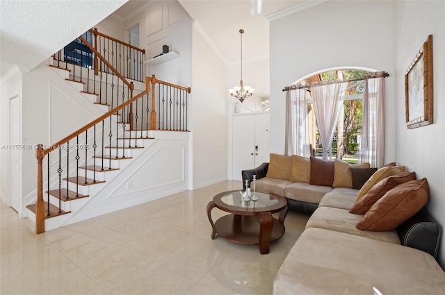 living area featuring a towering ceiling, stairs, and a decorative wall