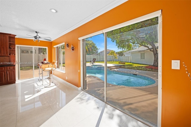 view of pool with ceiling fan and a pool with connected hot tub