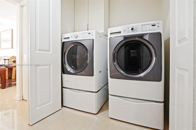 washroom featuring washing machine and clothes dryer, laundry area, and light tile patterned flooring