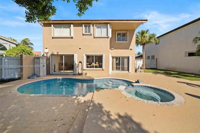 view of swimming pool featuring a patio, fence, and a pool with connected hot tub