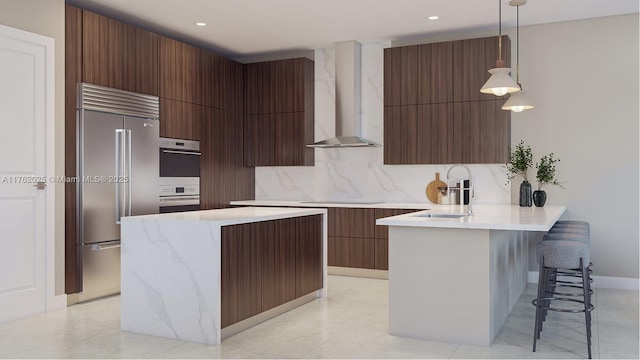 kitchen featuring built in refrigerator, a peninsula, modern cabinets, wall chimney exhaust hood, and a sink