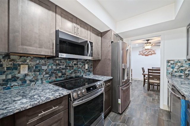 11696 NW 20th Dr Unit 11696, Coral Springs, FL 33071 - kitchen featuring stainless steel appliances, a ceiling fan, dark brown cabinets, light stone countertops, and decorative backsplash