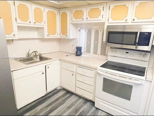 kitchen featuring a sink, stainless steel microwave, light countertops, and white range with electric cooktop