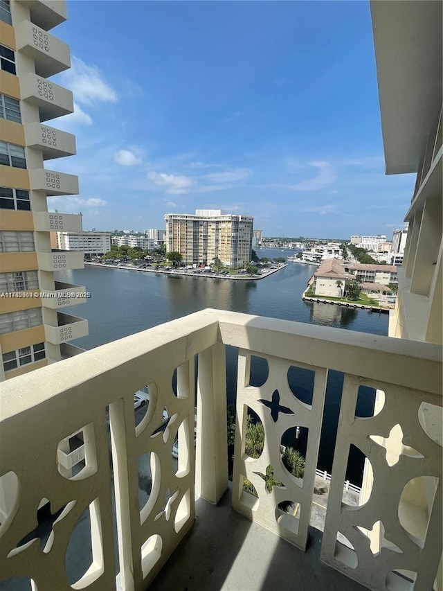 balcony with a water view and a view of city