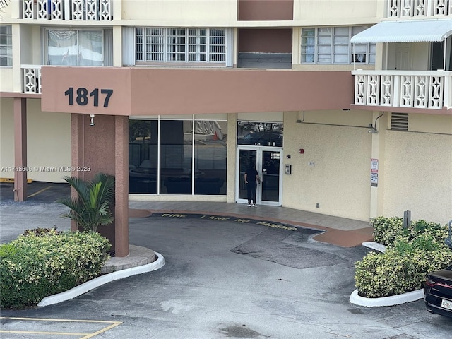 property entrance featuring uncovered parking and stucco siding