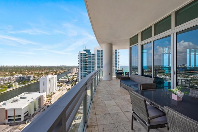 balcony featuring a water view and a city view