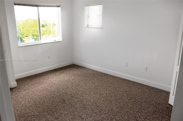 unfurnished room with baseboards and carpet