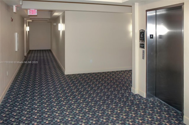 corridor featuring carpet flooring, elevator, and baseboards