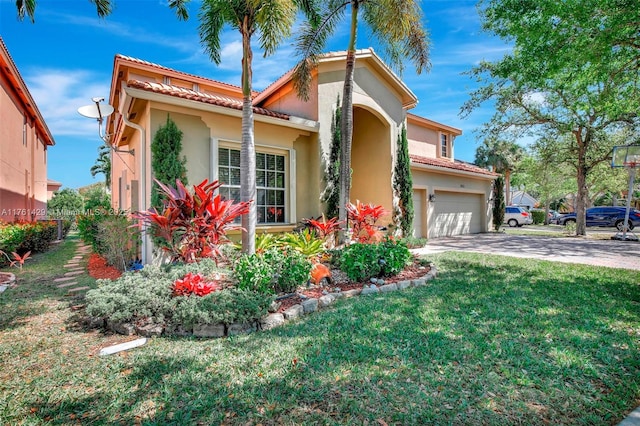 mediterranean / spanish-style home featuring stucco siding, driveway, a front yard, an attached garage, and a tiled roof