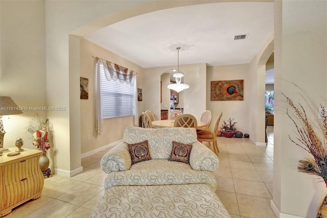 dining room featuring visible vents, light tile patterned flooring, baseboards, and arched walkways