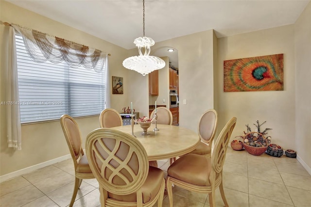 dining space featuring light tile patterned flooring and baseboards