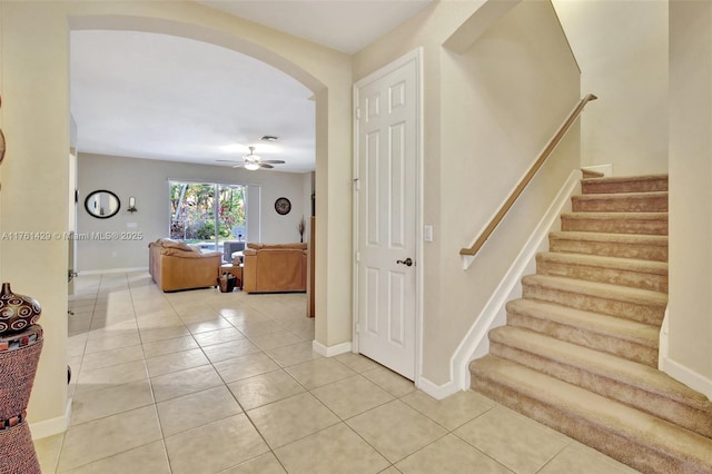 interior space with tile patterned floors, arched walkways, and baseboards