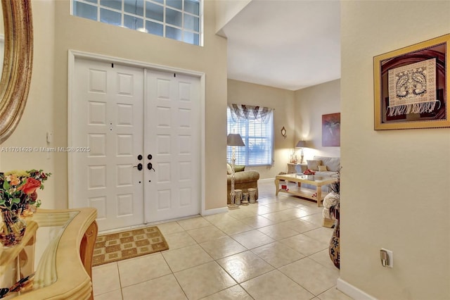 foyer featuring light tile patterned floors and baseboards