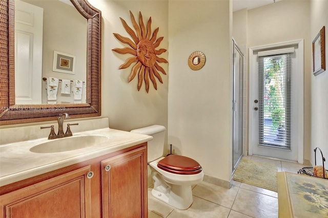 full bathroom featuring vanity, baseboards, tile patterned flooring, a shower stall, and toilet