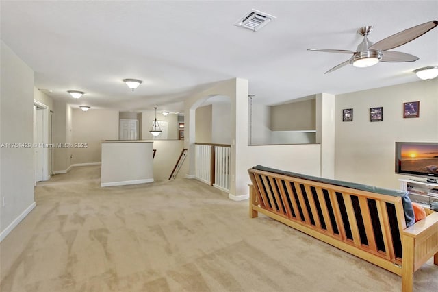 interior space featuring carpet, an upstairs landing, visible vents, and baseboards