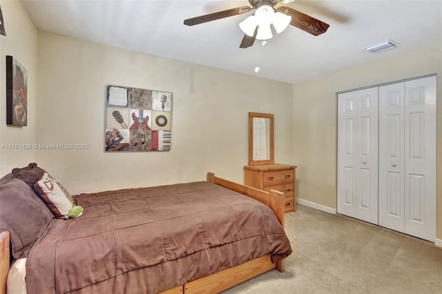 carpeted bedroom with baseboards, visible vents, a closet, and ceiling fan