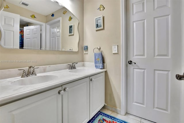 bathroom featuring tile patterned floors, double vanity, visible vents, and a sink