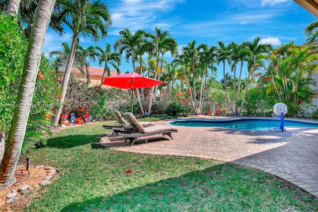 outdoor pool featuring fence, a patio area, and a lawn