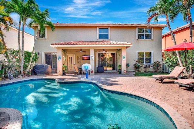 rear view of property featuring stucco siding, a patio, a ceiling fan, and a tile roof