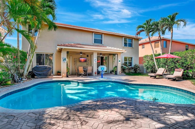 pool with a ceiling fan and a patio area