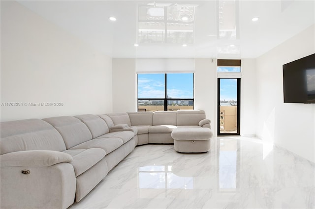 living area with recessed lighting and marble finish floor