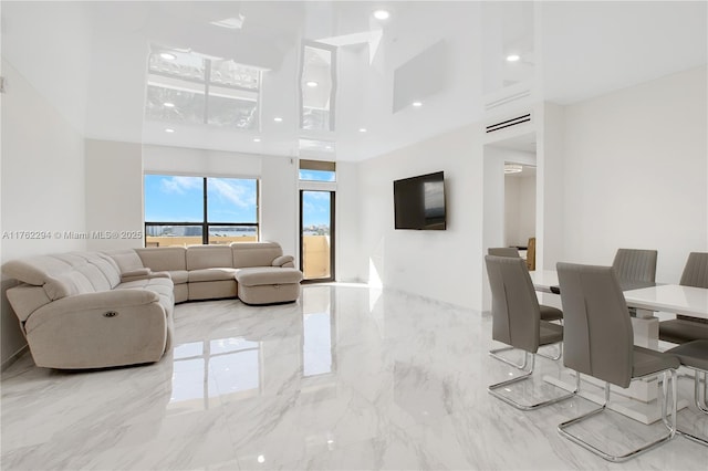 living room featuring a high ceiling, recessed lighting, and marble finish floor