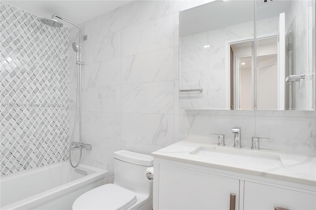 bathroom with vanity, shower / bathing tub combination, tile walls, toilet, and backsplash