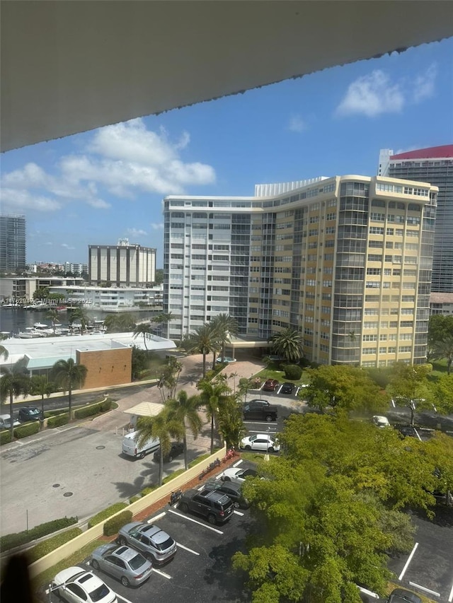 view of building exterior with a city view and uncovered parking