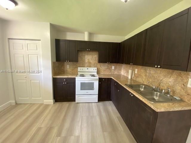 kitchen with white electric range oven, light wood-style floors, dark brown cabinetry, and a sink