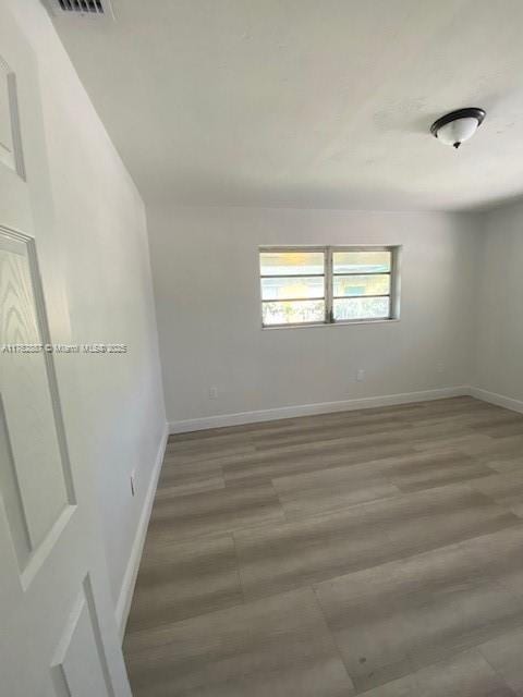 unfurnished room featuring baseboards and wood finished floors