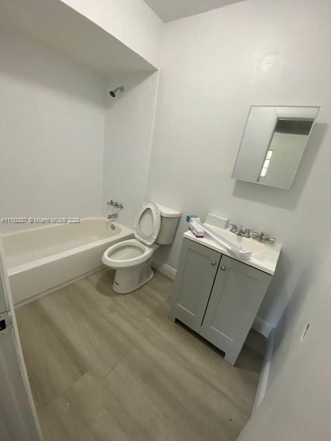 bathroom featuring vanity, shower / tub combination, toilet, and wood finished floors