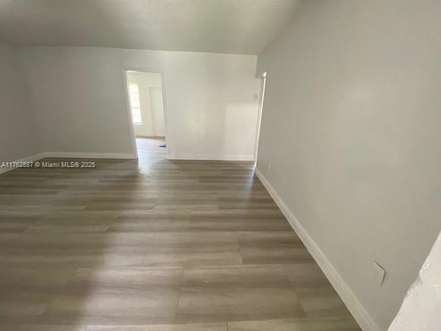 empty room featuring baseboards and wood finished floors