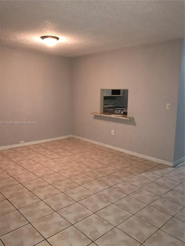 spare room with baseboards and a textured ceiling